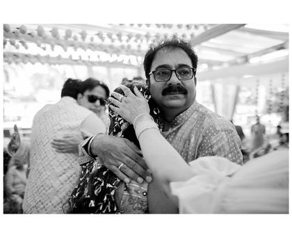 A touching black and white portrait of a father embracing his daughter on her wedding day. The emotion in this candid moment is palpable.