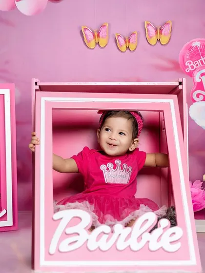 Always wear your invisible crown. A happy girl poses in a life-sized Barbie box in our fun and pink studio.