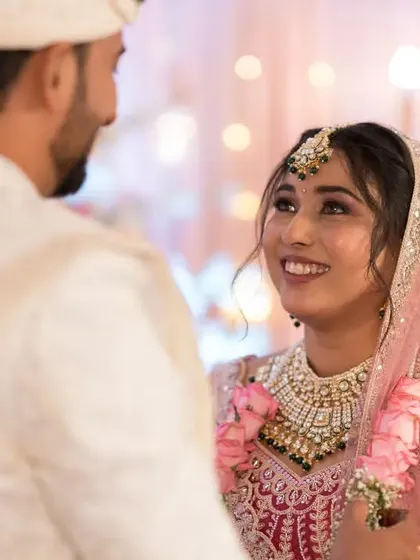 The bride looks at her groom with adoration, a beautiful candid moment captured during their wedding.