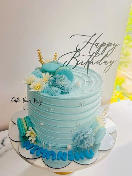 True blue celebrations. A beautiful blue cake topped with matching macarons and flowers.