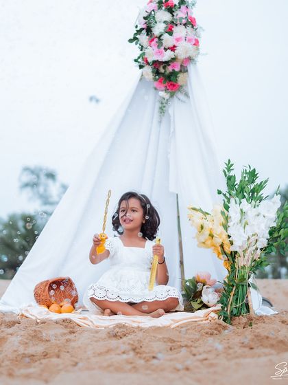 A wider shot of the beach teepee setup, complete with beautiful floral arrangements. This shows how I can create a fully styled scene for a unique and memorable kids' portrait session.