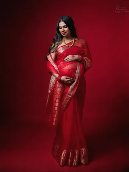 A vibrant red saree for a maternity shoot is pure elegance. I love incorporating traditional attire to create portraits that are both culturally rich and deeply personal.