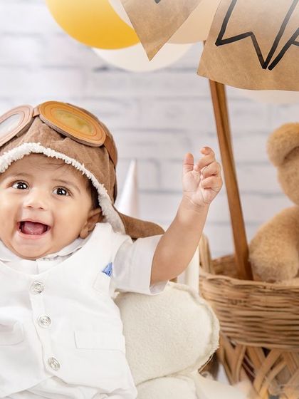 Cleared for takeoff! This little pilot is all smiles and ready to soar in his hot air balloon.