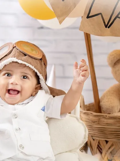 Cleared for takeoff! This little pilot is all smiles and ready to soar in his hot air balloon.