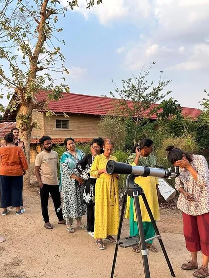 Adult learners line up to look through a telescope, experiencing the wonder of the cosmos firsthand during one of our contact class field trips.