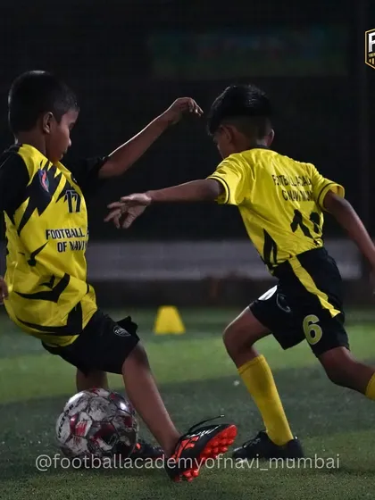 Young players learning to shield the ball and use their body to maintain possession in a tight space.