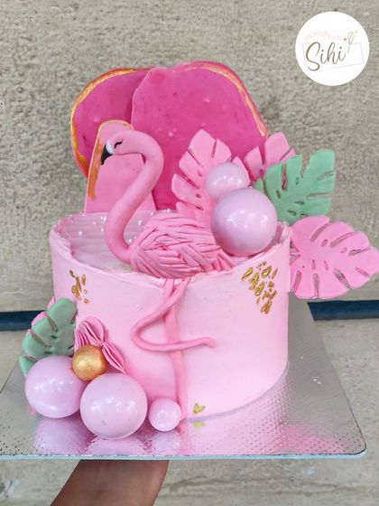 Flamin-got my heart. This vibrant pink flamingo cake is perfect for a tropical-themed party, featuring a fondant flamingo, monstera leaves, and pink baubles.