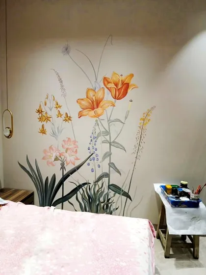 The completed floral mural in the bedroom setting, with my painting supplies nearby, showing the transition from concept to reality.