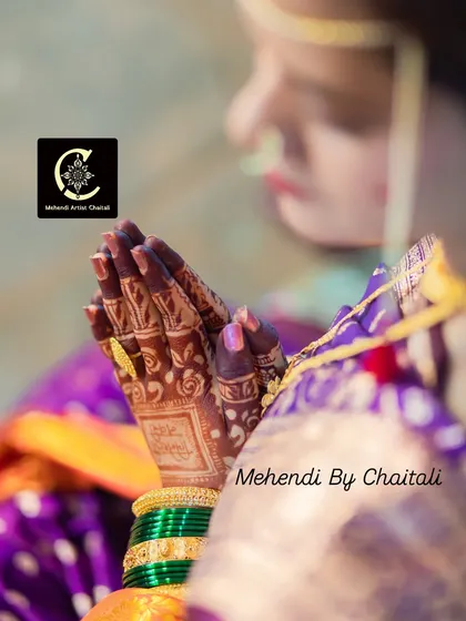This shot highlights the rich, dark stain of the mehendi, which I achieve using my own organic henna cones. The color beautifully complements the bride's green bangles and purple saree.