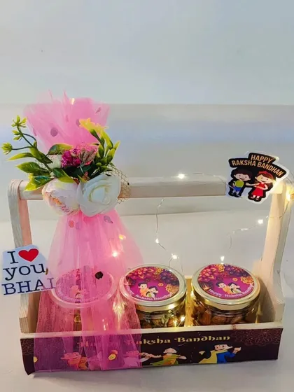 Another view of the three-jar wooden basket hamper for Rakhi, decorated with pink tulle and fairy lights.
