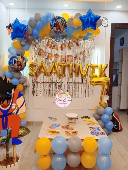 A complete Dragon Ball Z themed 7th birthday party setup with a character cutout, balloon arch, and themed table.