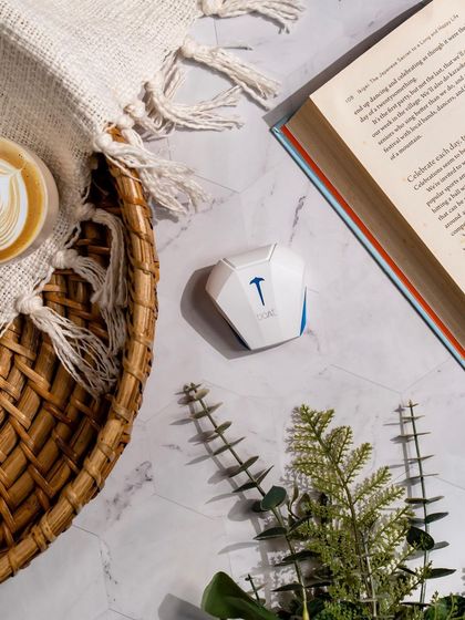 Audio meets aesthetics with boAt Airdopes. This cozy flat-lay combines the earbuds with a cup of coffee, a book, and a woven placemat, creating a relaxing and aspirational lifestyle image.
