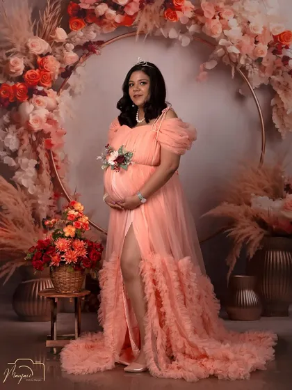A full-length shot showcasing the magnificent ruffled gown against the beautiful floral ring. A truly breathtaking image.