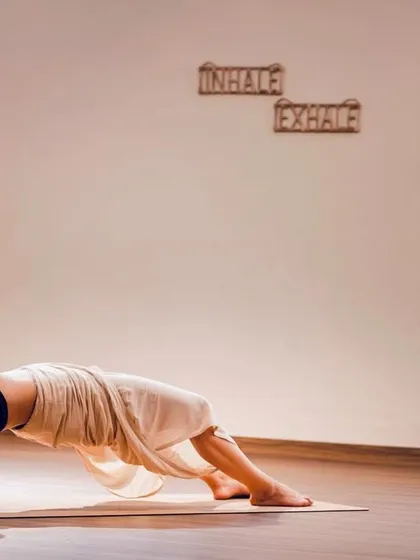 A black and white artistic shot of my supported backbend, emphasizing the graceful curve of the spine.