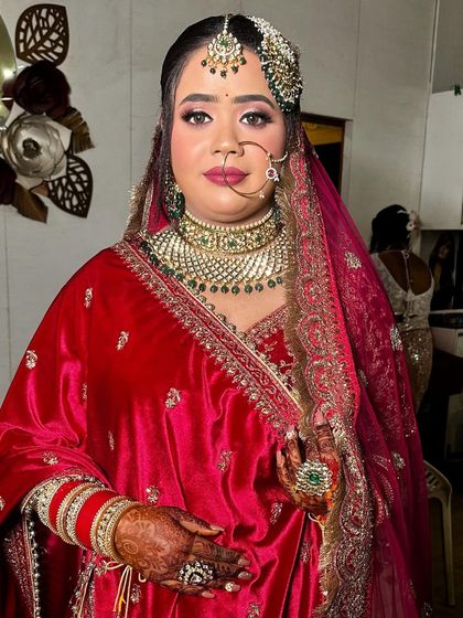 A portrait of my bride in her red velvet outfit. The makeup features a sharp wing liner and a deep pink lip for a classic bridal look.
