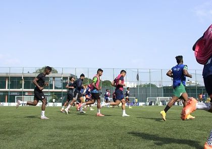 A wide shot of professional footballers warming up on the field during an off-season camp. This shows the scale of our programs and the organized, professional approach I bring to every session.
