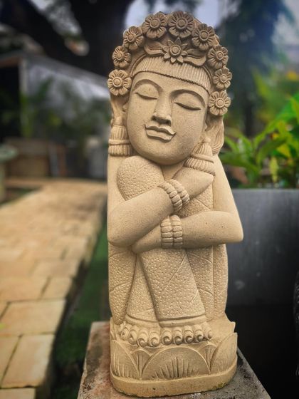 A close-up of our sandstone garden doll. The artisan has captured a serene expression and detailed the floral crown and traditional clothing, making it a beautiful piece of art.