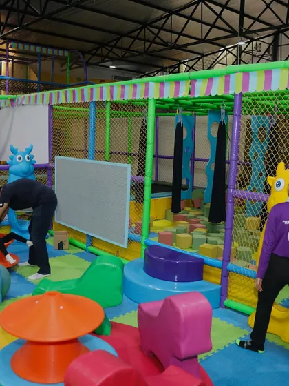 Our staff is always on hand to ensure a safe and fun environment, seen here assisting a child in the toddler play area.