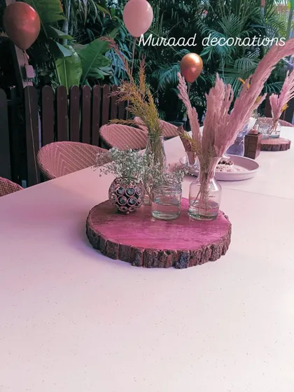 A rustic yet chic table centerpiece from the 21st birthday party. A slice of wood serves as the base for small vases with pampas grass and other dried florals.