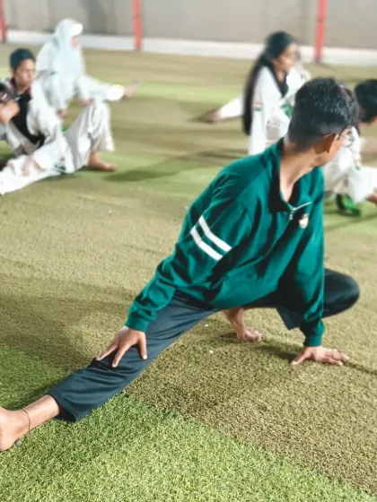 A student focuses on his stretching. We teach our students that flexibility is a long-term commitment that pays off in every aspect of their Taekwondo practice.
