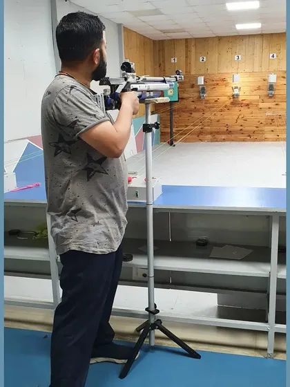 A shooter using a stand to support his rifle, a common practice for sighting and making adjustments. We teach all aspects of equipment handling.