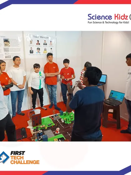 The team gathers for a final briefing before their presentation at the First Tech Challenge. This moment shows the focus and teamwork required to compete at the national level.