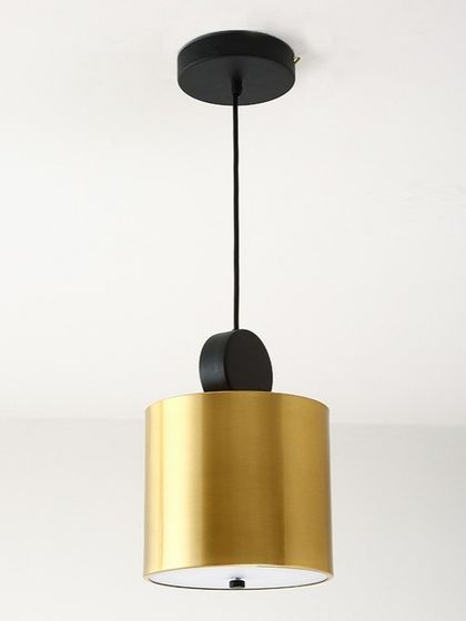 A close-up view of a modern geometric pendant light with a wide cylindrical shade. The combination of matte black and brushed gold offers a sophisticated, two-tone finish suitable for contemporary home decor.