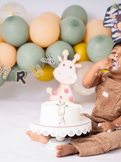 A wild one cake smash in full swing. This little cub is enjoying his first taste of birthday cake, surrounded by his jungle friends. Themed sessions add a magical touch to the milestone.