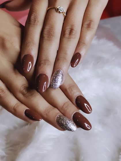 A classic and chic combination of a solid brown polish with sparkling silver glitter accent nails.