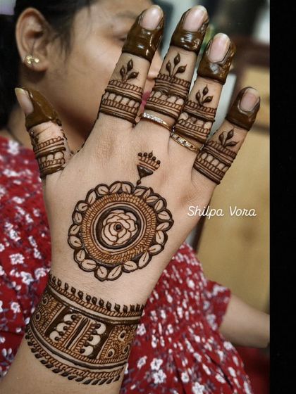 A beautiful mandala design on the back of the hand with a matching cuff, a popular choice for festive occasions.