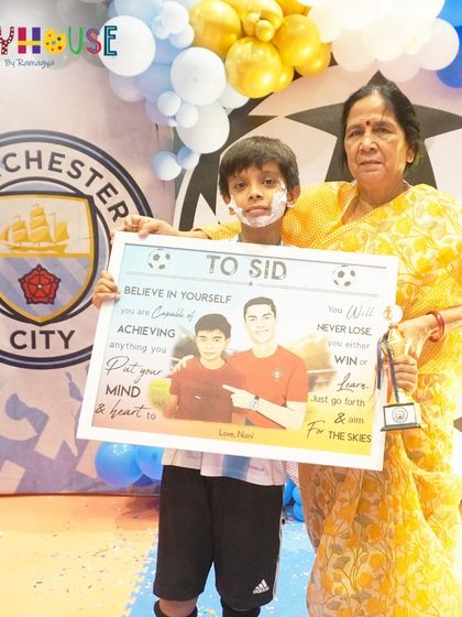 A touching moment as the birthday boy receives a personalized gift from his grandmother at his football party.