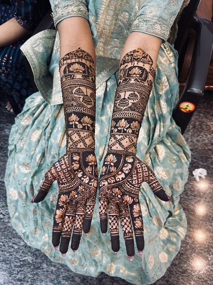 A dense and dark design featuring lotuses and kalash motifs, with fully covered fingertips for a traditional look.