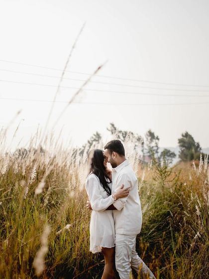 An intimate embrace in a field of tall grass. The soft focus and natural setting make this a beautifully romantic and private moment.