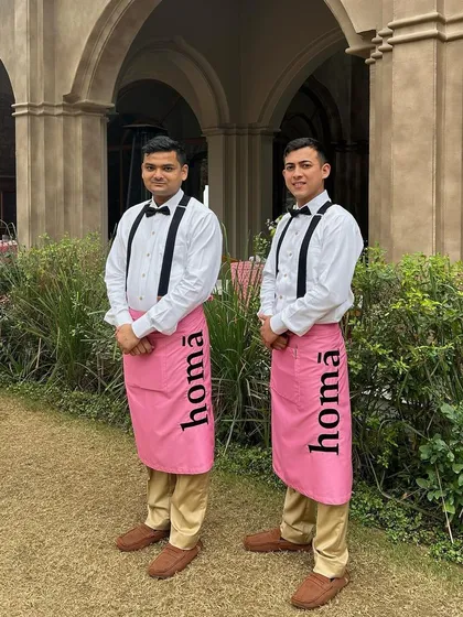 Our professional service staff in their signature pink Homā aprons, ready to welcome guests at a luxury event at Six Senses Fort Barwara.