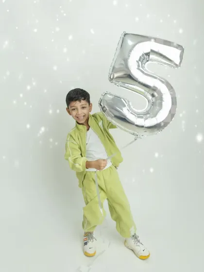 So much energy and fun! The birthday boy is having a great time playing with his giant number five balloon.