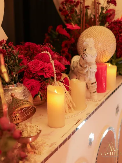 Every detail matters. This tabletop vignette features pillar candles, strings of pearls, and rich red florals, creating a small moment of beauty and intimacy.