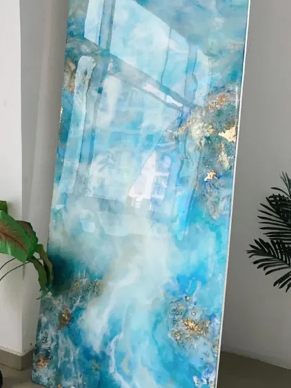 An abstract ocean art panel with flowing blues, whites, and hints of gold foil, creating a sense of movement and depth like waves crashing on the shore.