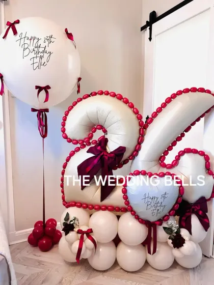 Celebrating a 25th birthday in style. This custom balloon arrangement features the number '25' in elegant white and red, detailed with bows and a personalized jumbo balloon. We can create this in any color scheme and for any age.