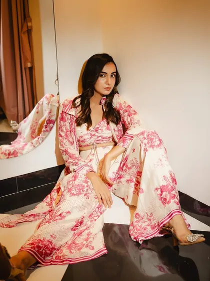 A chic, seated pose in a floral outfit. The makeup is kept soft and pretty to complement the romantic print of the clothing.