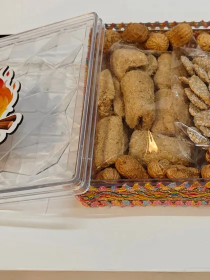 The Lohri gift box with the lid open, showing the assortment of traditional sweets inside.