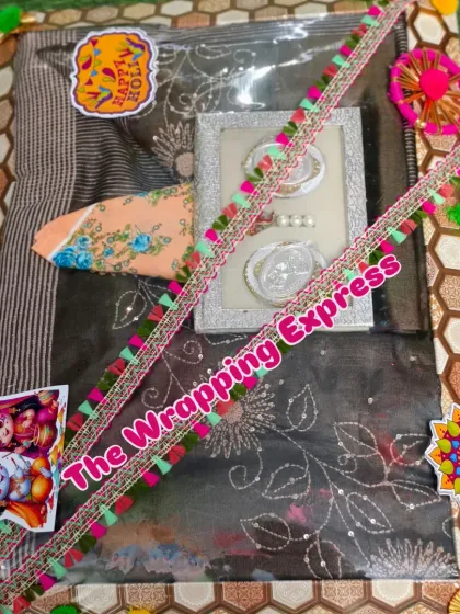 A traditional saree packed as part of a Holi gift, decorated with festive stickers and colorful lace.
