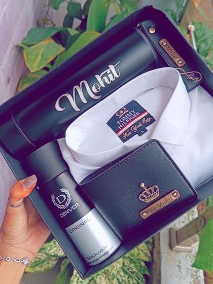 A classic and elegant gift set, this hamper includes a personalized wallet, a name-engraved temperature bottle, a matching keychain, a branded shirt, and men's deodorant.