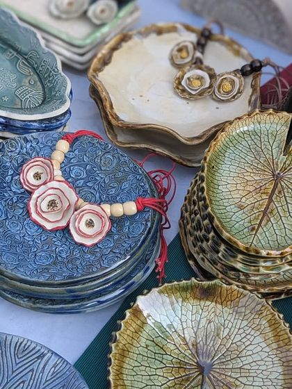 A variety of my textured plates on display. You can see the blue floral necklace I made, which was inspired by the pattern on the plates next to it.