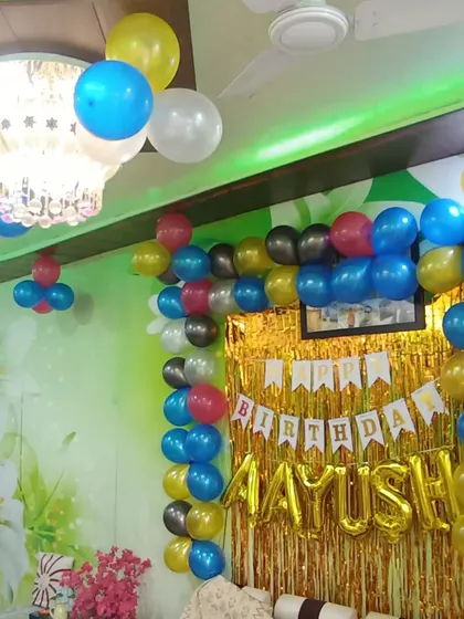 A colorful and simple birthday decoration at home. The gold shimmer curtain and balloon frame are a great way to add a festive touch to any wall.