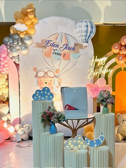 A detailed shot of the pastel teddy bear and hot air balloon stage, showing the cute props and floral arrangements.