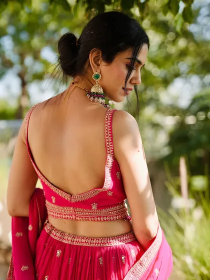 It's all in the details. This shot highlights the beautiful back and intricate embroidery of a festive pink lehenga, perfect for a daytime wedding function. I focus on capturing the craftsmanship that makes each piece special.