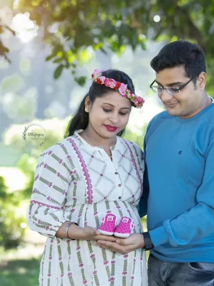 A sweet preview of the little one on the way. This couple holds up a tiny pair of pink baby shoes, a classic and heartwarming prop for a maternity announcement photo.