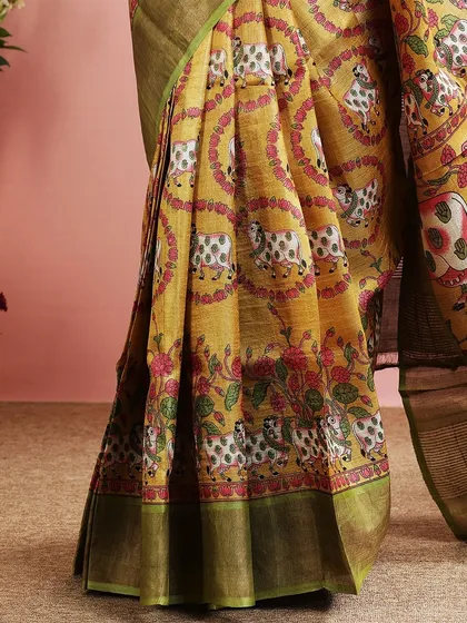 A detailed shot of the lower part of the saree, showing the intricate print and the green border.
