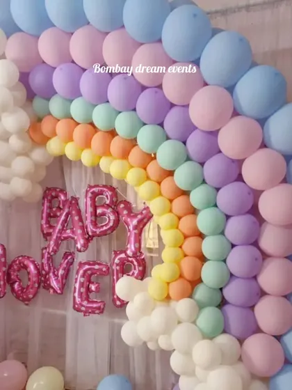 A clear shot of the pastel rainbow balloon arch, perfect for a joyful baby shower. The arrangement of colors from blue to pink to yellow creates a beautiful and eye-catching focal point.