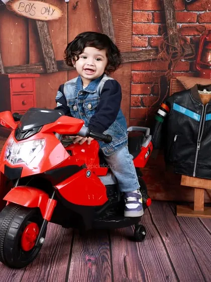 This little biker is ready to hit the road. Our garage-themed shoot, complete with a toy motorcycle and leather jacket, is perfect for a cool and edgy look.